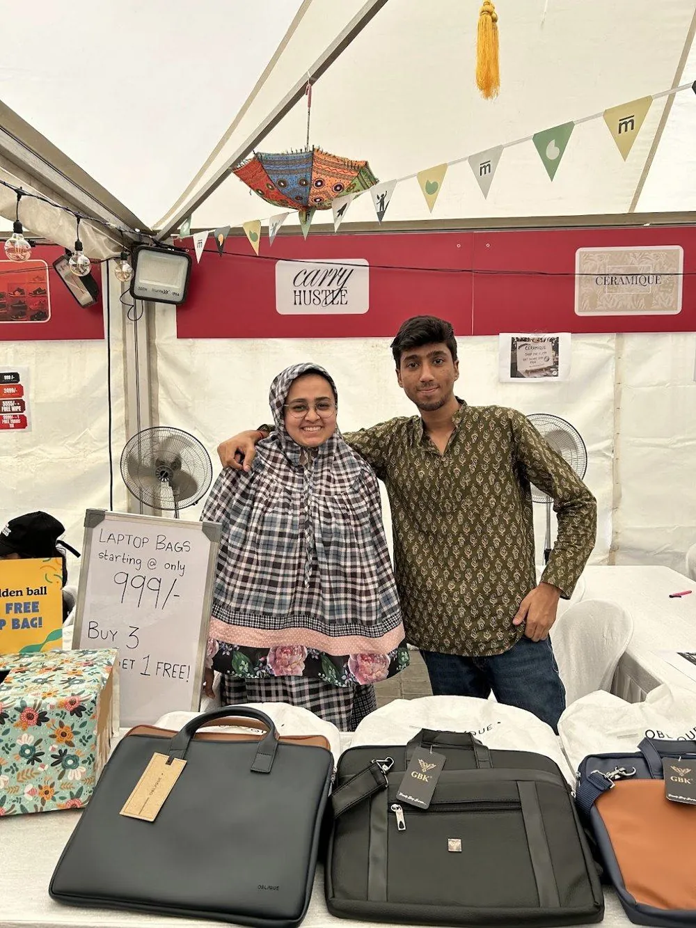 Two students at their BYOB laptop bag stall