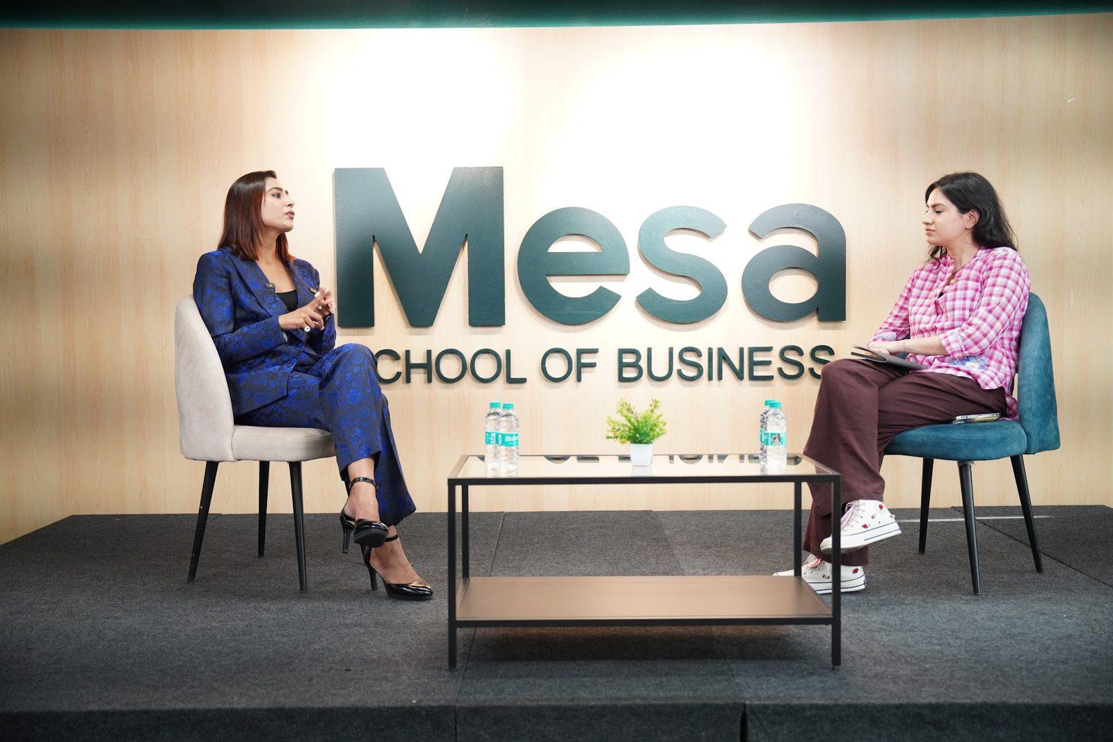 Ghazal Alagh in conversation with Dyumna Madan on stage in front of the Mesa School of Business wall