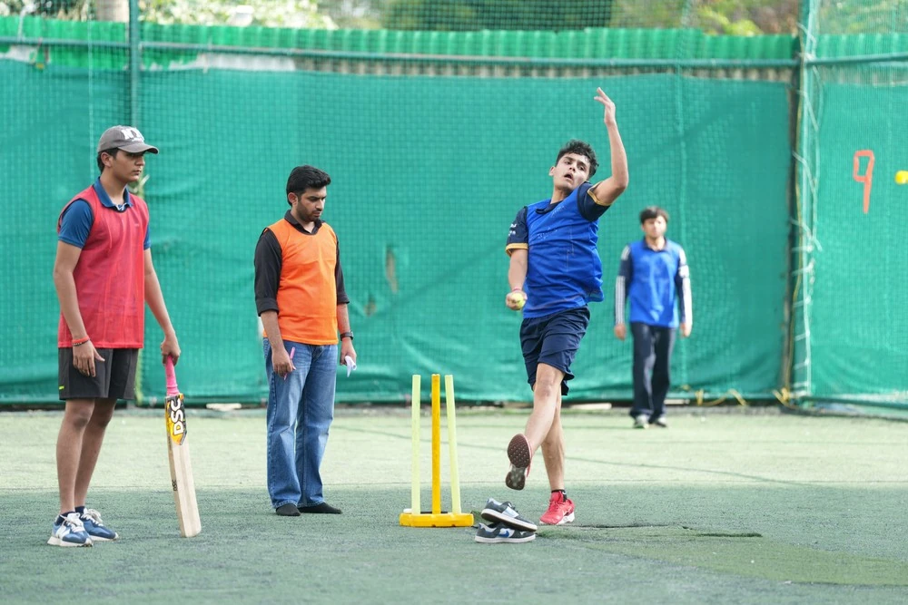 A student bowling in the cricket nets
